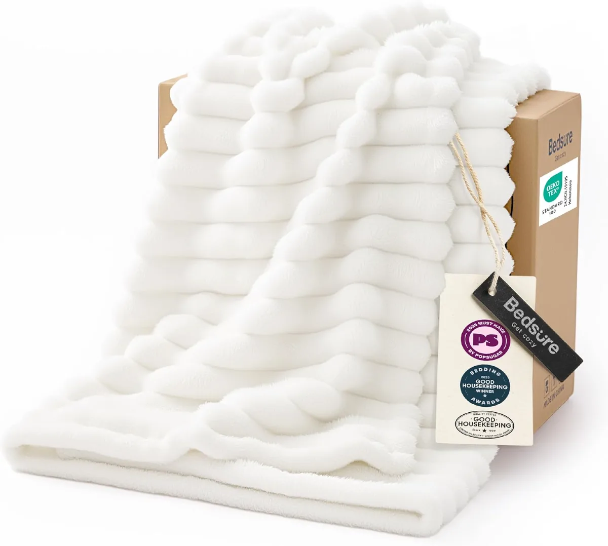 Flat lay of last minute gifts that look expensive: scented candle set, plush throw blanket, jewelry organizer, silk pillowcase, gold sunflower necklace, waterproof Bluetooth speaker